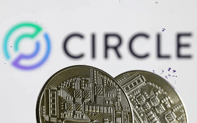 Physical USDC stablecoin tokens in front of the Circle logo, representing digital currency and blockchain-based payments