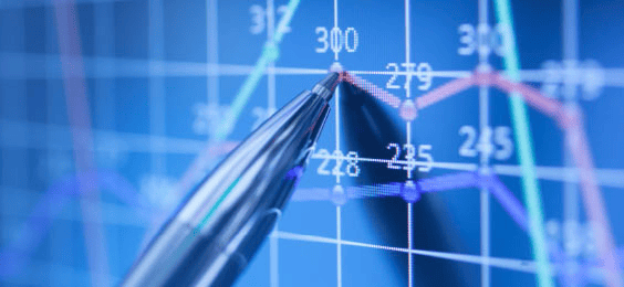 A close-up of a pen pointing at a line graph with numerical values and intersecting trend lines on a blue digital background. The chart highlights data points and performance metrics.