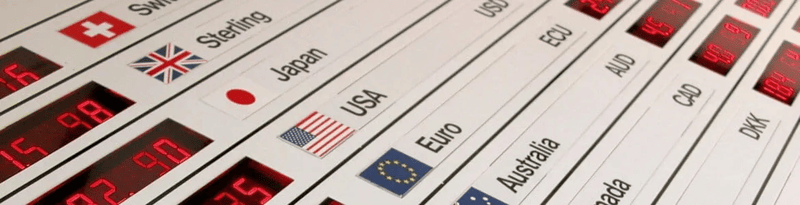 Electronic exchange rate board displaying multiple currencies with country flags and changing numerical values