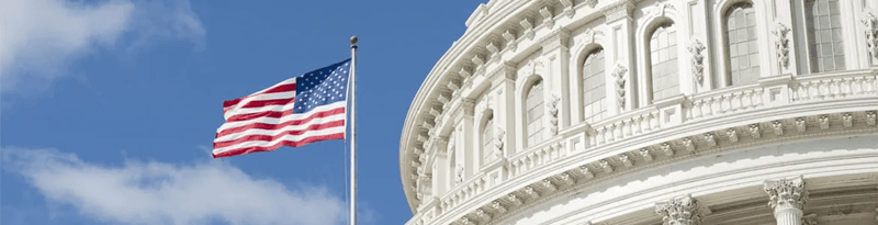 United States Capitol building exterior with the American flag flying against a blue sky