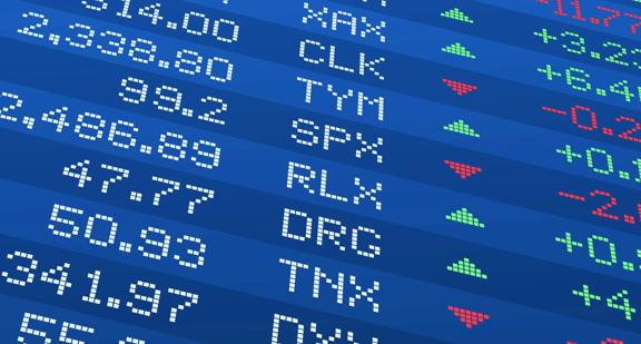 Close‑up of a stock market display with numeric prices, company abbreviations, and trend indicators.