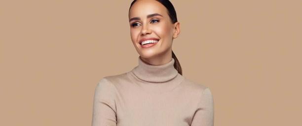 Woman wearing beige Skims polo neck shapewear top