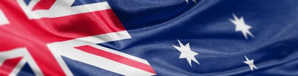 Australian national flag with Union Jack and white stars waving against a clear blue sky.