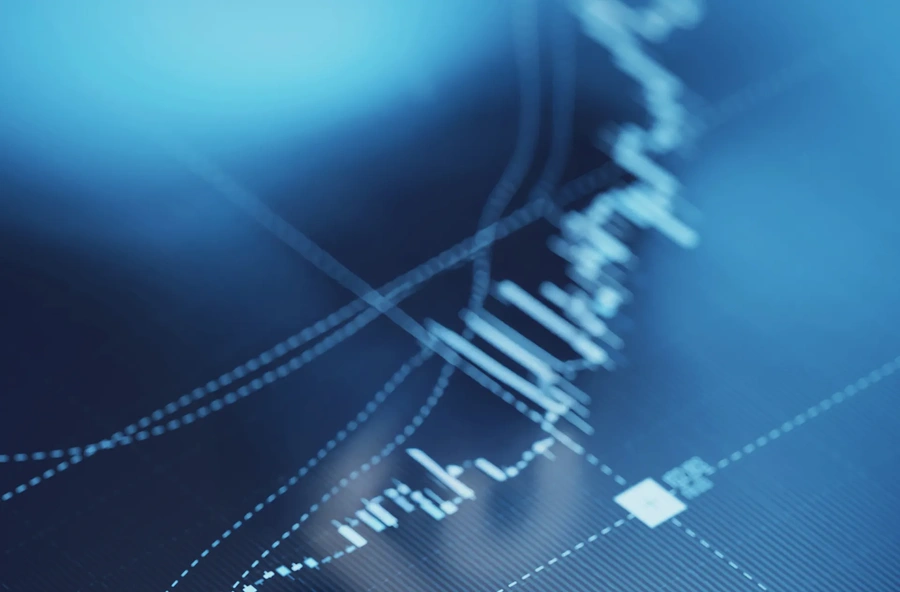 Close-up of a digital financial chart with white lines and data points on a blue background representing market trends