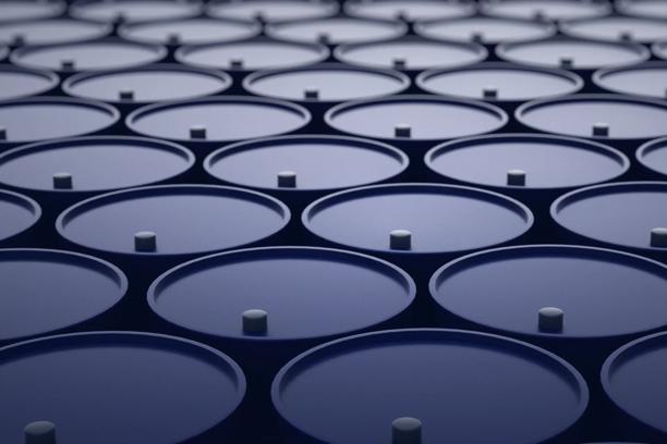 Close-up of blue industrial barrels with circular lids and central caps arranged in rows