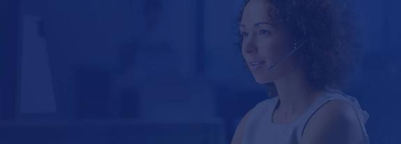 Customer support representative wearing a headset while assisting clients through digital communication channels and online support services.