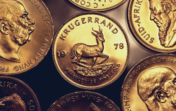 Collection of gold coins featuring a 1978 South African Krugerrand with a springbok antelope, surrounded by various international gold coins with historical designs.