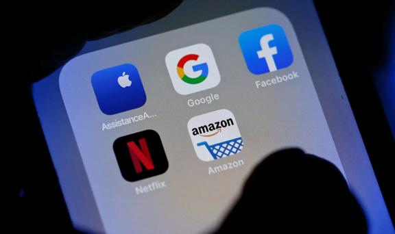 Close-up of a smartphone screen displaying popular app icons including Apple Google Facebook Netflix and Amazon.