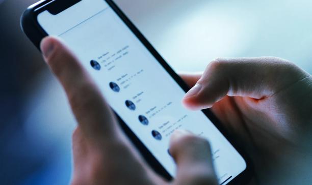 Close-up of a person using a smartphone to browse through a list of messages