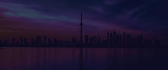 Silhouette of Toronto skyline at dusk with CN Tower reflected on calm water
