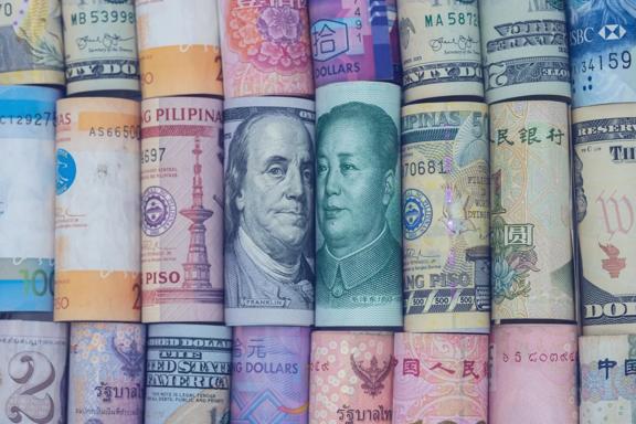 Rolled international banknotes from different countries displayed side by side, representing global currencies and foreign exchange markets.