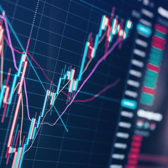 Close up of a digital stock market chart with candlestick patterns and colorful trend lines